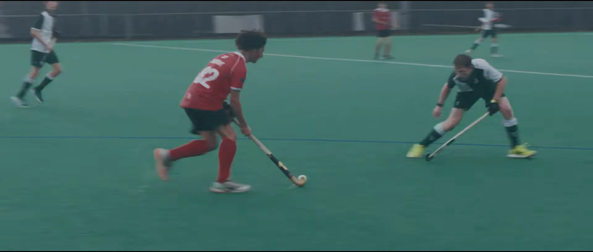 Hockey match on a blue pitch